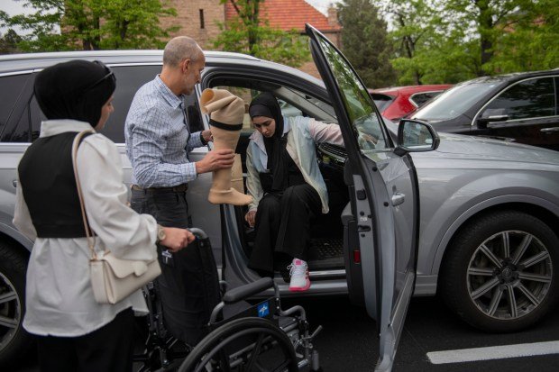 Savaşta yaralanan Gazzeli gence, mutfak masası amputasyonundan sağ kurtulan Colorado'da yapay bacak takıldı 4 Dr. Omar Mubarak, left, Vascular surgeon at the Vascular Institute of the Rockies, assists Ahed Bseiso, 18, with her prosthetic while loading into a car Saturday, May 18, 2024, in Boulder. Bseiso lost leg after the building she was in was hit by a shell in Gaza. Her leg was amputated on her kitchen table by her uncle who is an orthopedic surgeon. (Photo by Daniel Brenner/Special to The Denver Post)