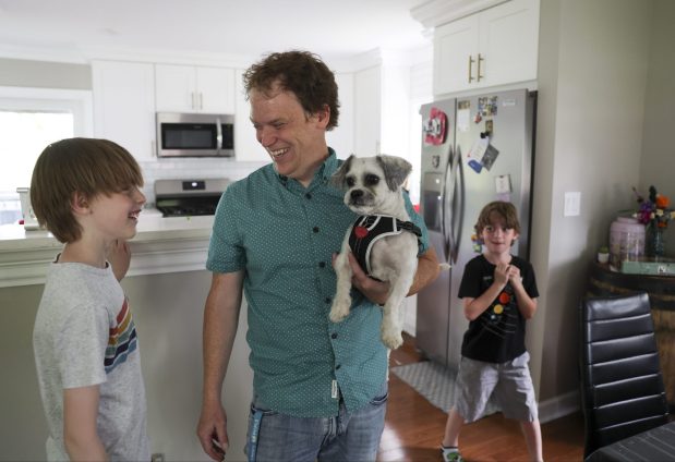 Çalışma, yeni babaların da doğum sonrası depresyon açısından taranması gerektiğini söylüyor 1 Joel Gratcyk holds their new dog Falkor as he hangs out with his sons Wesley, 11, left, and Theodore, 7, in their home in Arlington Heights on June 12, 2024. (Eileen T. Meslar/Chicago Tribune)