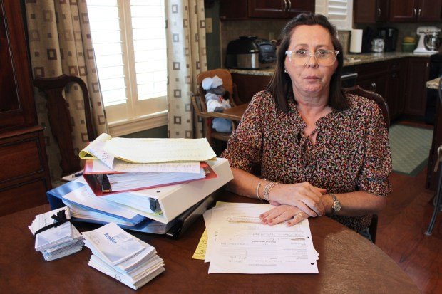 'Dipsiz bir kuyu': Cepten ödenen TMJ masrafları hastaları nasıl borca sürüklüyor? 1 A woman sits at a table stacked with paperwork